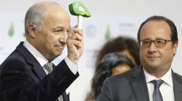 Le president de la COP21, Laurent Fabius, donne un coup de marteau symbolique pour marquer l'officialisation de l'accord sur le climat au côtés du président français, François Hollande, le 12 décembre 2015 au bourget